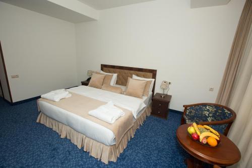 a bedroom with a bed and a table with fruit on it at Faria Boutique Hotel in Tsaghkadzor