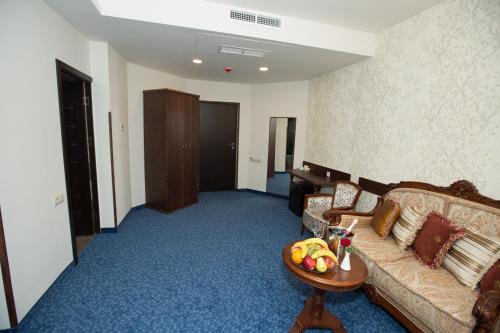 a living room with a couch and a table with a bowl of fruit at Faria Boutique Hotel in Tsaghkadzor