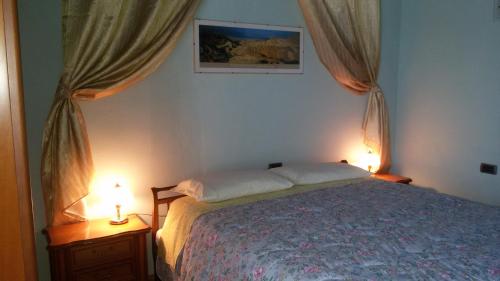 NervianoにあるStorica Quercia B&Bのベッドルーム1室(ベッド1台、テーブルにランプ2つ付)