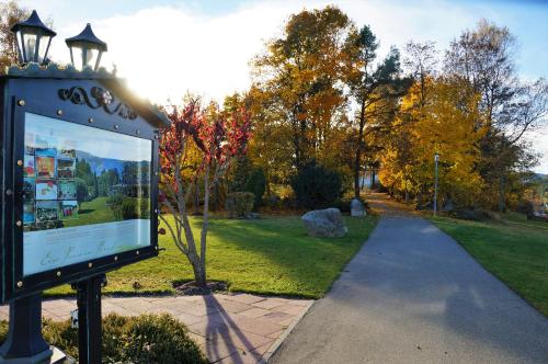 a sign in a park next to a sidewalk at Parkhotel Flora am Schluchsee in Schluchsee