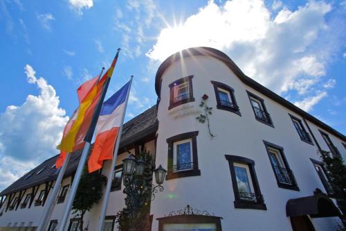 un bâtiment avec des drapeaux sur son côté dans l'établissement Parkhotel Flora am Schluchsee, à Schluchsee