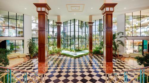 a lobby with a checkered floor and windows at Hipotels Natura Palace Adults Only in Playa Blanca