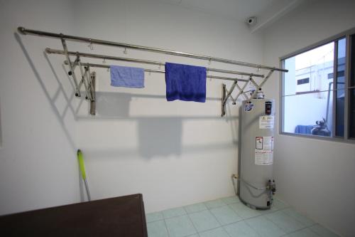 a bathroom with a refrigerator and blue towels at Come Inn Homestay 1379 in Miri