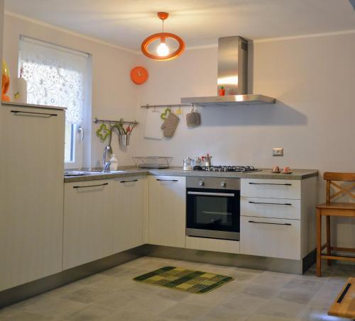 a kitchen with white cabinets and a stove top oven at Casina dello Zio in Verbania