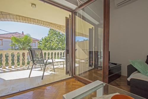 a room with a glass door with a chair on a balcony at Lux dodo in Dramalj