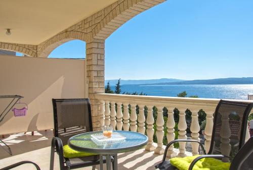 a table and chairs on a balcony with a view of the water at Lux dodo in Dramalj