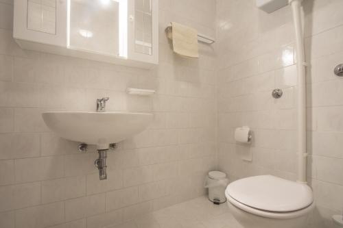 a white bathroom with a sink and a toilet at Lux dodo in Dramalj