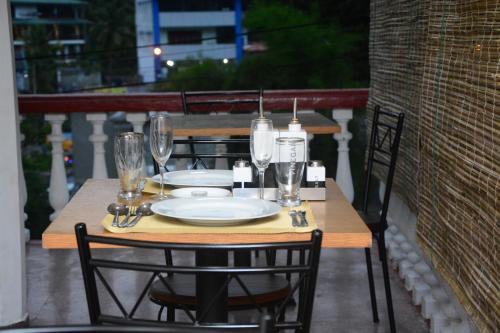 a wooden table with glasses and a plate on it at Lodge in 611 in Kandy