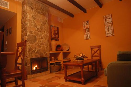 a living room with a fireplace and a couch at Hotel Apartamento Rural Finca La Media Legua in Aracena