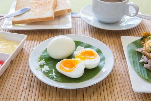 een bord eieren op een tafel met een kopje koffie bij Boonme Heritage in Phitsanulok