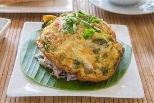 een bord eten op een bord op een tafel bij Boonme Heritage in Phitsanulok