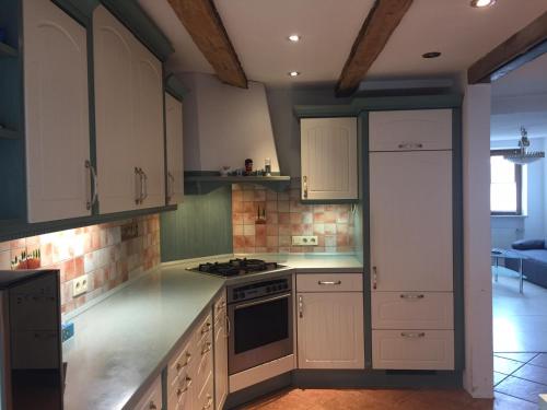 a kitchen with white cabinets and a stove top oven at Boardinghouse Schnaitheim in Heidenheim