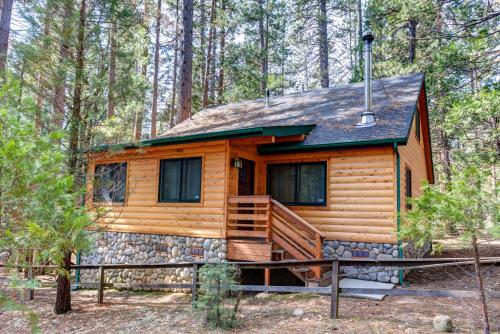 a cabin in the woods with a stone wall at 2N Big Pine Lodge in Wawona