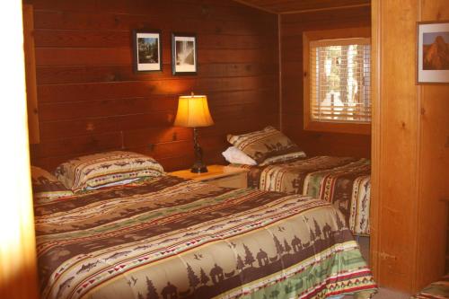 une chambre avec deux lits et une lampe sur une table dans l'établissement 76 Howards Retreat, à North Wawona