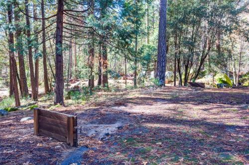 a wooden bench sitting in the middle of a forest at 50R Soots-Me in Wawona