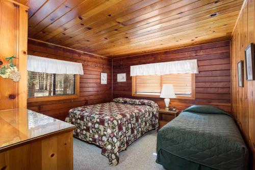 a bedroom with two beds in a wooden cabin at 55 Deer Creek in Wawona