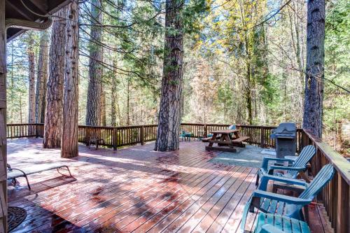 a deck with benches and a picnic table in the woods at 50R Soots-Me in Wawona