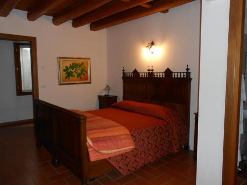 Un dormitorio con una cama roja en una habitación. en La Torre del Falco, en San Vito al Tagliamento