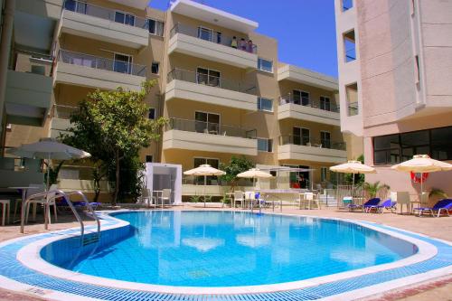 a large swimming pool in front of a building at Michel Apartments in Kos