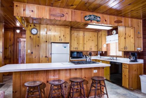 a kitchen with wooden walls and bar stools at 55 Deer Creek in Wawona