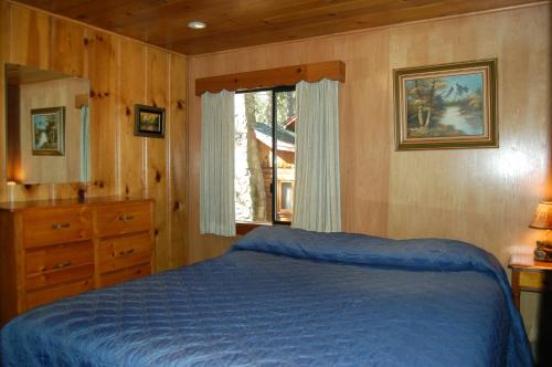 a bedroom with a blue bed and a window at 26 Deer Den in North Wawona