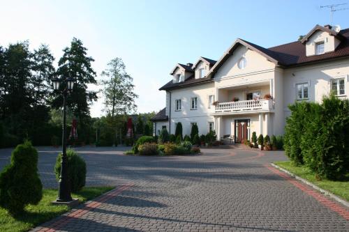 a large white house with a driveway at Gościniec Kuklówka in Kuklówka