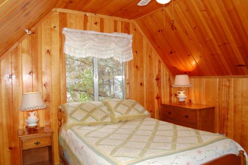 a bedroom with a bed with wooden walls and a window at 44R Grant's Camp in Wawona