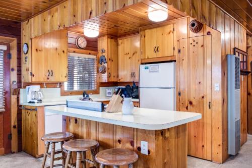 a kitchen with wooden walls and a refrigerator and stools at 70 Simmons Den in Wawona