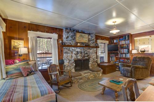 a living room with a stone fireplace and a couch at 80 Chattertons Cottage in North Wawona