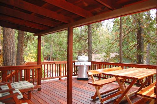 a wooden deck with a grill and a picnic table at 8 Nugents Nest in North Wawona