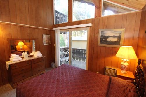 Schlafzimmer mit einem Bett, einer Kommode und einem Spiegel in der Unterkunft 6B Meadow View in Wawona