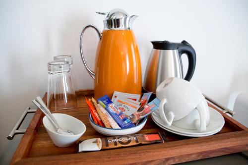 a table with a tray with a coffee maker and food at The Rez Guesthouse in Walvis Bay