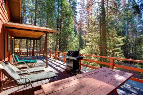 a screened in porch with a picnic table and a grill at 9B Deer Hollow in Wawona
