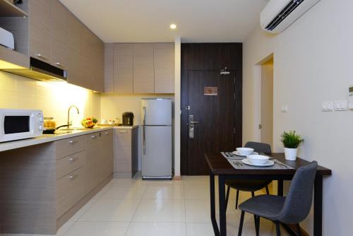 a small kitchen with a table and a refrigerator at Altera Hotel and Residence by At Mind in Pattaya Central