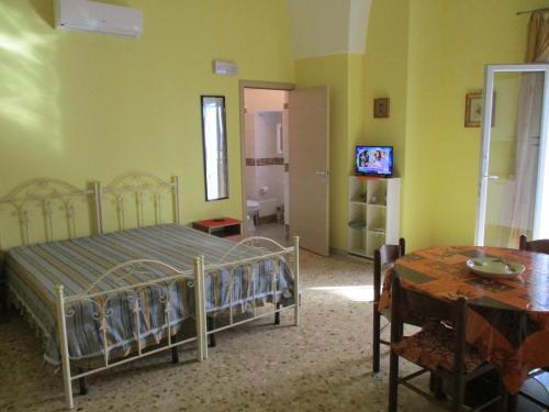 カザラーノにあるAlba Dorataのベッドルーム(ベッド1台、テーブル、テレビ付)