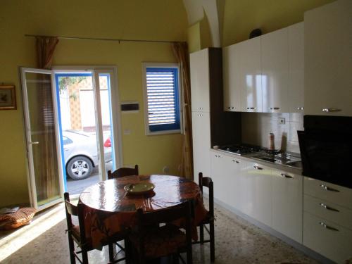 a kitchen with a table and a kitchen with a car at Alba Dorata in Casarano