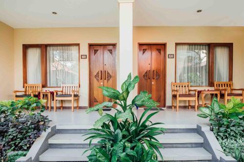 a lobby with tables and chairs and plants at Kuta Puri Bungalows, Villas and Resort in Kuta