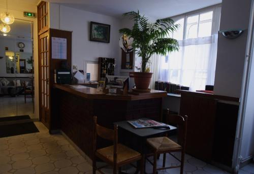 - un bar avec une table et des chaises dans la chambre dans l'établissement Hotel Anya, à Paris