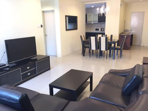 a living room with a couch and a tv and a table at Elegant Suites at Taragon Bukit Bintang in Kuala Lumpur