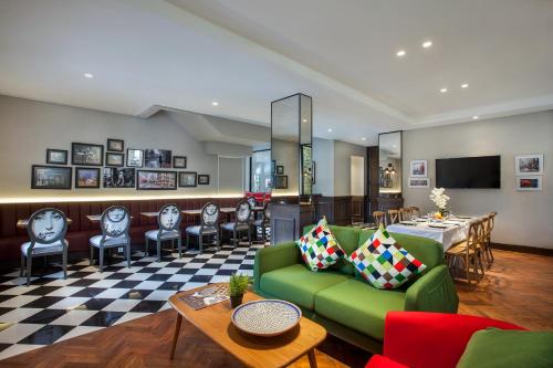 a living room with a green couch and chairs at White Tree Residence in Jakarta