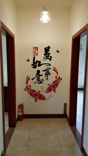 a room with a wall with chinese characters on it at 好宿民宿 in Jinning