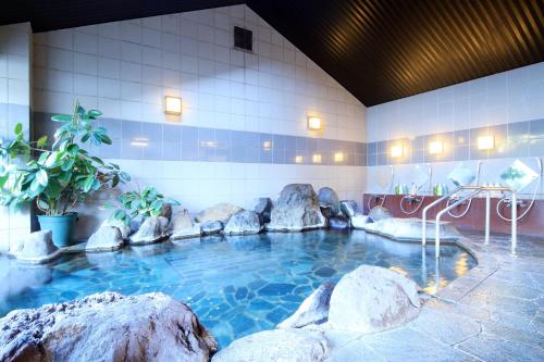 - une piscine avec des rochers dans un bâtiment dans l'établissement Yanagiya, à Kōfu