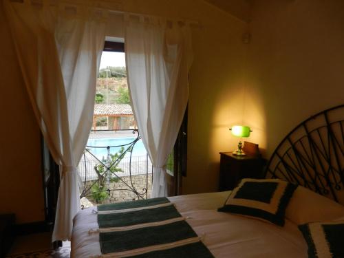 a bedroom with a bed and a window with a view at Vecchia Dimora Resort in Centuripe
