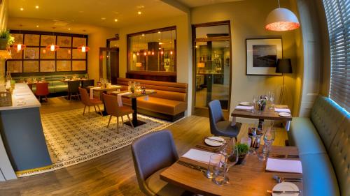 a restaurant with tables and chairs and a bar at The Orchid Hotel in Bournemouth