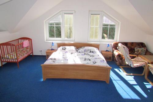 a bedroom with a bed and a couch and two windows at Wellness Villa u Prahy-all inclusive in Čerčany