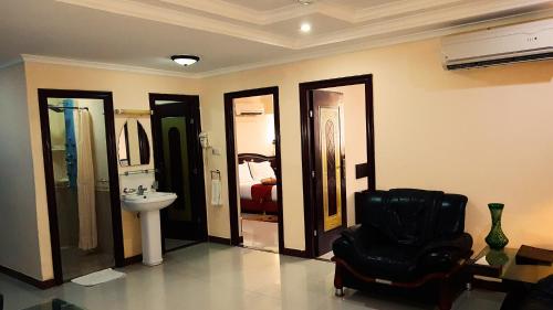 a bathroom with a black chair and a sink at Urban Rose Hotel & Apartments in Dar es Salaam