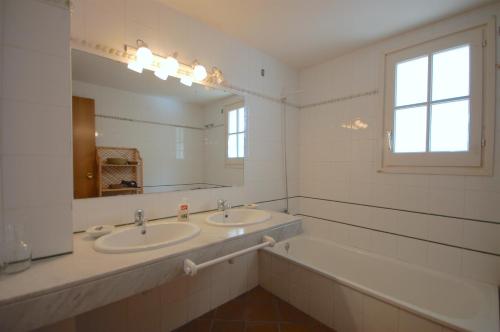 a bathroom with two sinks and a large mirror at Lets Holidays Sailor House with Sea Views in Tossa de Mar