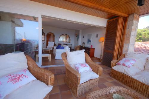Habitación con sillas de mimbre y sala de estar. en Lets Holidays Sailor House with Sea Views, en Tossa de Mar