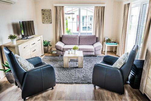 a living room with two chairs and a couch at Chalet 31 in Serooskerke