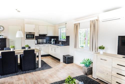 a kitchen and living room with a table and chairs at Chalet 31 in Serooskerke